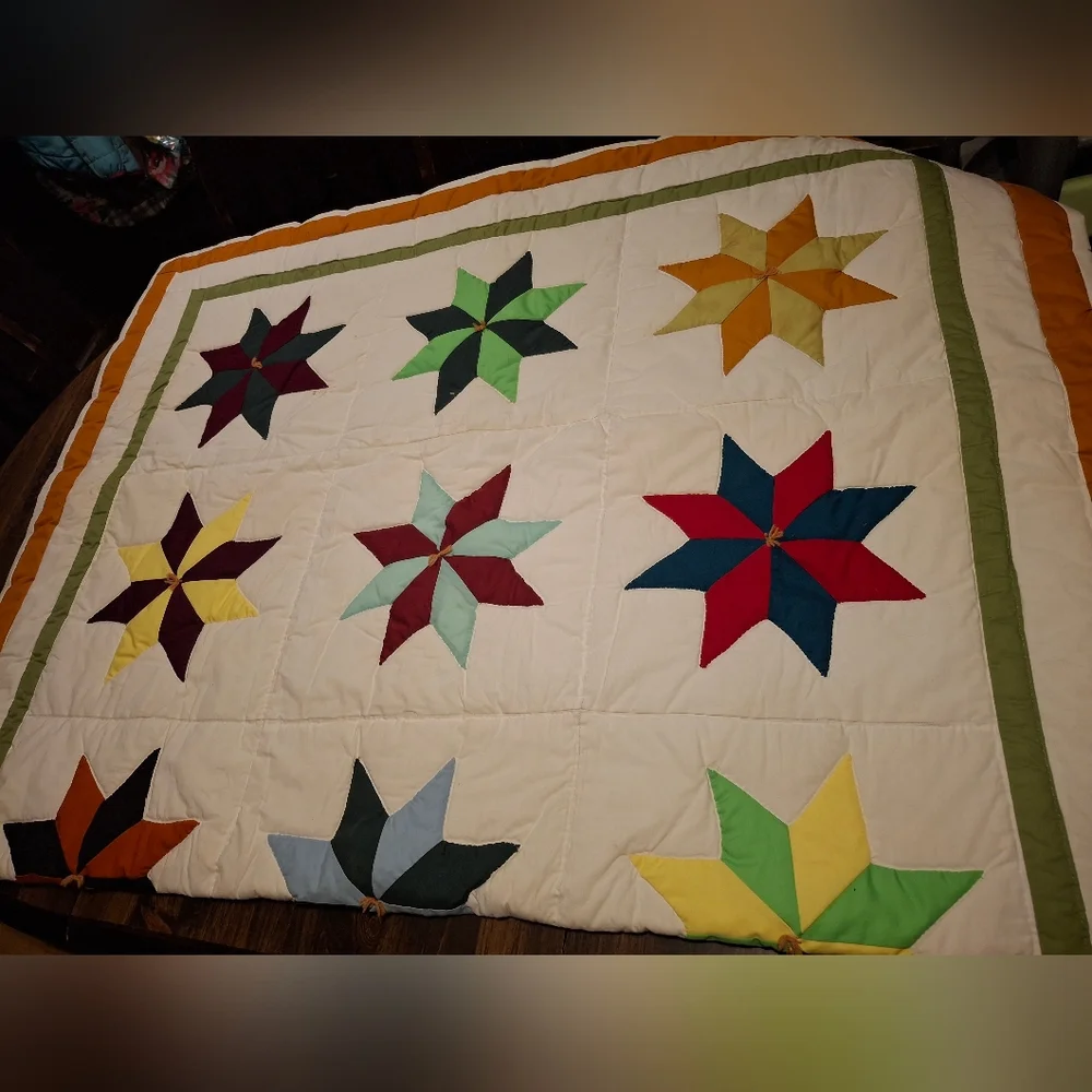 This colorful handmade quilt features a unique 8-point star pattern